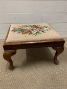 A mahogany foot stool on cabriole legs and tapestry seat pad (H26cm W43cm D38cm)