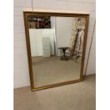 A wall mirror in a gilt frame with carved leaf boarder (146cm x 118cm)