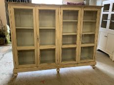 A double display cabinet with glaze front and bun feet (H167cm W215cm D39cm)