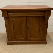 A mahogany cupboard with drawers to top and carved floral ends (H82cm W89cm D38cm)