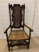 A carved open armchair with cane back and seat