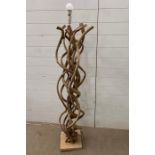 A floor standing lamp made of twisted wood