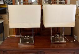 A pair of chrome table lamps with cream shades (H63cm)