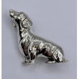 A silver dachshund brooch.