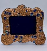 A large copper and enamel easel back picture frame