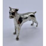 A white metal figure of a Boxer Dog