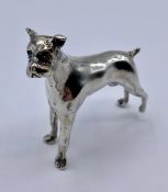 A white metal figure of a Boxer Dog