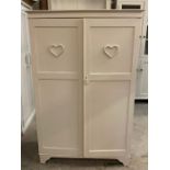 A small painted clothes cupboard or hall cupboard with heart decoration to both doors (H152cm W100cm