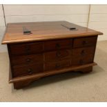An Indian hardwood coffee table opening up to storage space and drawers to side (H40cm SQ75cm)