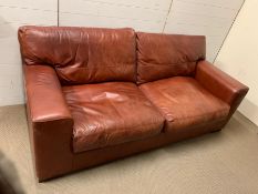 A three seater oxblood leather sofa (H95cm W217cm D97cm SH79cm)