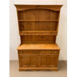 A pine Welsh dresser with plate rack and small dresser on top of a two door cupboard (H185cm