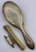 A Hallmarked silver backed desk blotter and a hallmarked silver backed brush.