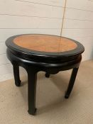 An ebonised style circular side table with inlay walnut style top (57cm H x 63 cm D)