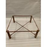 A metal frame coffee table with twisted iron work to legs and cross stretcher (H43cm 103cmsq)