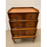 A waterfall front chest of drawers with three drawers on brass castors (H70cm W48cm D43cm)
