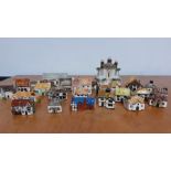A collection of twenty eight collectable miniature ceramic and pottery hand painted houses, made