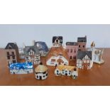 A collection of thirteen collectable miniature ceramic and pottery hand painted houses, made in