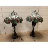 A pair of Tiffany style lamps with grapes and vines design to shade with a patinated bronze style