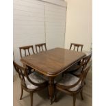 A six seater dining table with two extension leaves on reeded legs (H76cm W150cm D109cm extensions