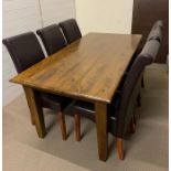 A dining room table with six leather effect chairs