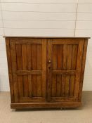 An oak two door cupboard with one internal shelf (H107cm W112cm D47cm)