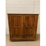 An oak two door cupboard with one internal shelf (H107cm W112cm D47cm)