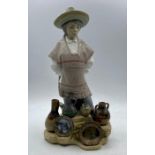 A Lladro figure of a person selling pottery