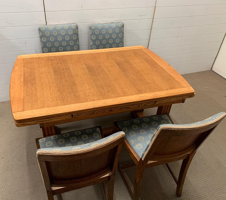 An oak table with reeded legs, extends both sides and four matching chairs (H77cm W126cm D84cm)