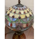 A Tiffany style table lamp with a blue, green and red dots to shade