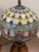 A Tiffany style table lamp with a blue, green and red dots to shade