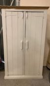 A two door wooden cupboard opening to shelves and a small hanging rail (H187cm W112cm D60cm)