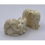 A Pair of carved netsukes one elephant and one dragon