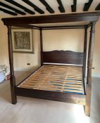 A stained pine four poster bed with slatted frame base