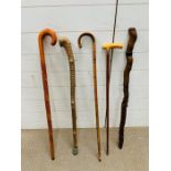 A selection of vintage walking sticks including a silver collared walking cane