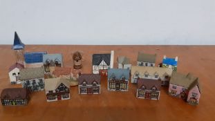 A collection of seventeen collectable miniature ceramic and pottery hand painted houses, made in