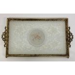 A vintage piece of lace framed in a brass tray