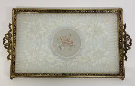 A vintage piece of lace framed in a brass tray