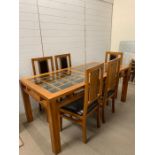 An oak dining room table with square pattern to top and five chairs