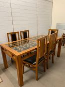 An oak dining room table with square pattern to top and five chairs