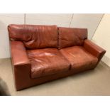 A three seater oxblood leather sofa (H95cm W217cm D97cm SH79cm)