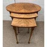 A walnut nest of table, three nesting tables on pad feet (Largest H52cm W60cm D42cm)