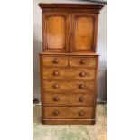 A Victorian mahogany cupboard on chest with surmount on moulded cornice, two panelled doors