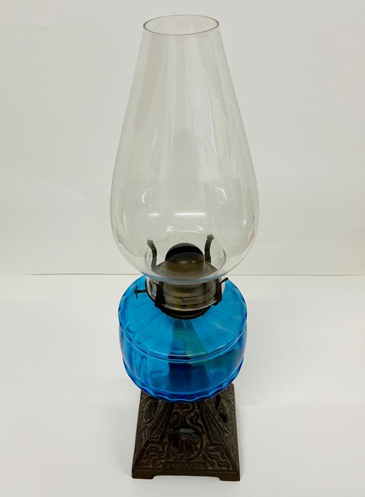 A cast iron and blue glass Art Nouveau oil lamp.