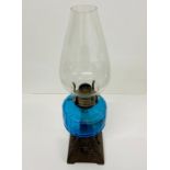 A cast iron and blue glass Art Nouveau oil lamp.