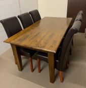 A dining room table with six leather effect chairs