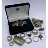 A selection of silver jewellery including charms, lockets and rings