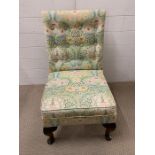 A low bedroom chair on cabriole legs and upholstered in William Morris style fabric