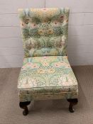 A low bedroom chair on cabriole legs and upholstered in William Morris style fabric