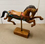 A carved display horse on plinth (H89cm W110cm)