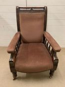 A Victorian mahogany salon gentleman's chair with foliate carving and baluster turnings